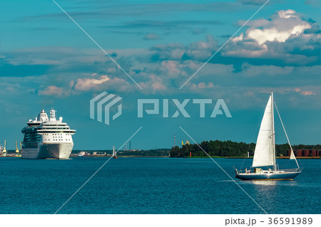 Blue sailboat against cruise liner Blue sailboat against cruise liner 36591989
