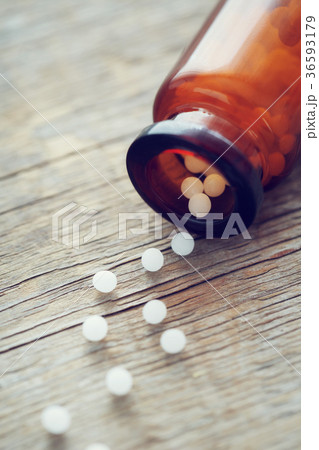 Scattered homeopathic globules and bottle. 36593179