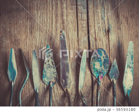 Row of artist palette knifes on wooden backdrop 36593180