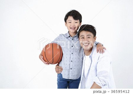 Young father and son playing with a ball and riding  a bicycle together portrait. Studio shot. 058 36595412