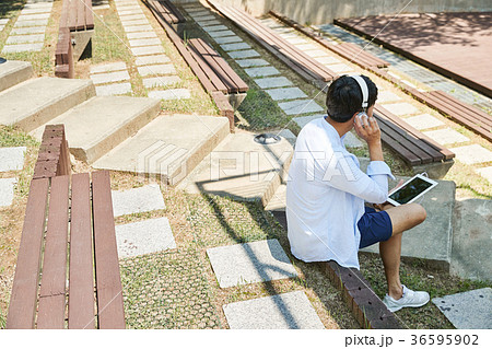 Young guy take a relax in park, sit on green grass and walking in around. 041 Young guy take a relax in park, sit on green grass and walking in around. 041 36595902