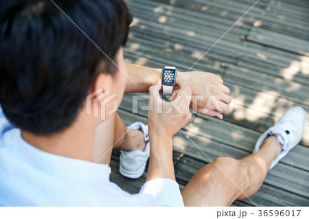 Young guy take a relax in park, sit on green grass and walking in around. 014 36596017