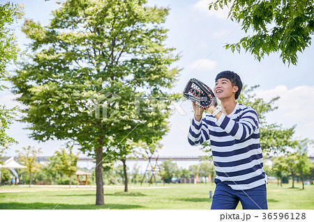 Young guy take a relax in park, sit on green grass and walking in around. 114 Young guy take a relax in park, sit on green grass and walking in around. 114 36596128