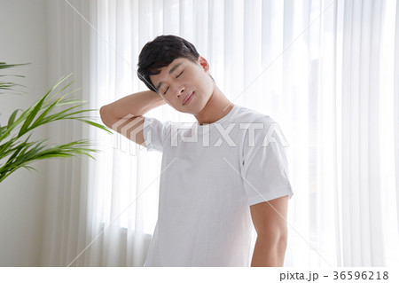 Young guy standing at the front of window with bright sunlight. 152 36596218