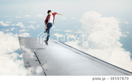 Boy riding skateboard on wing Boy riding skateboard on wing 36597870