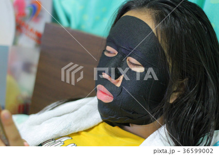Young beautiful woman is having a black mask  36599002