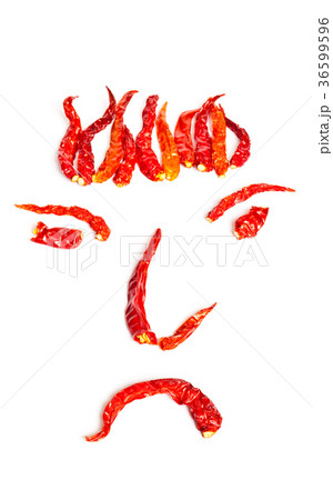Dried red hot chillies in a Face shape on white Dried red hot chillies in a Face shape on white 36599596