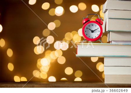Vintage alarm clock and pile of books Vintage alarm clock and pile of books 36602649
