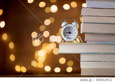 Vintage alarm clock and pile of books 36602651