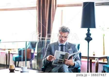 Mature businessman reading newspapers in a hotel 36607487
