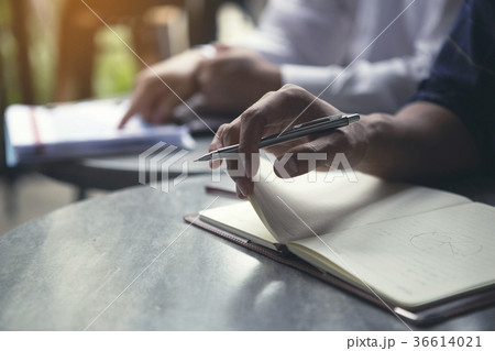 Men are opening book to take note of ideas. 36614021