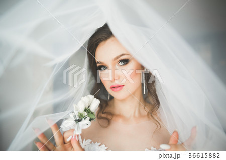 Luxury bride in white dress posing while preparing 36615882