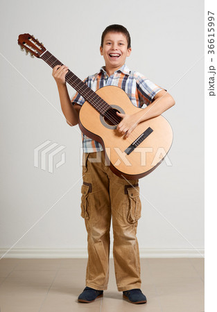 Boy is playing the acoustic guitar  36615997