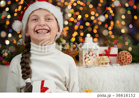 Girl dressed in santa hat with christmas gifts Girl dressed in santa hat with christmas gifts 36616152