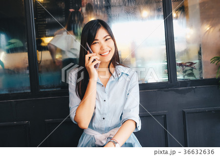 Smiling women talking on smart phone in cafe 36632636