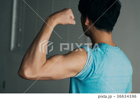 力こぶをつくる男性 後ろ姿 筋肉の写真素材