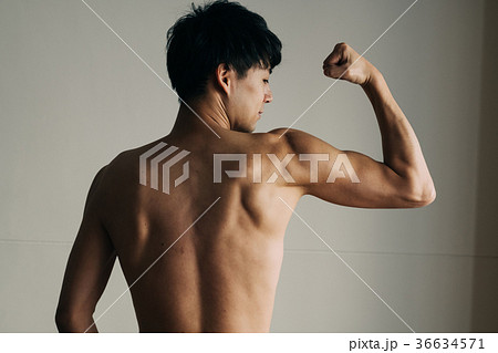 力こぶ 若い日本人男性 上腕二頭筋 広背筋の写真素材