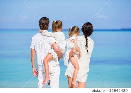 Back view of a happy family on tropical beach Back view of a happy family on tropical beach 36642420