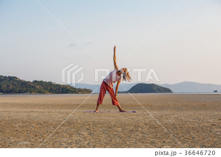 Man is doing yoga on the beach 36646720
