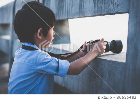 Cute Asian boy taking photo by digital camera  36655482