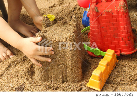 Close up of a child's hand playing sand toys. 36657035