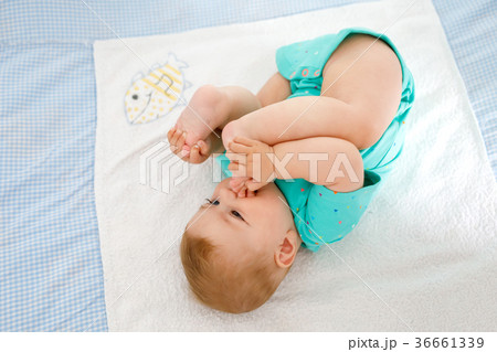 Cute baby taking feet in mouth. Adorable little 36661339