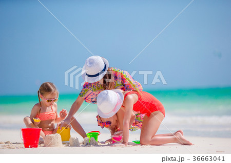 Mother and two kids playing with sand on tropical Mother and two kids playing with sand on tropical 36663041