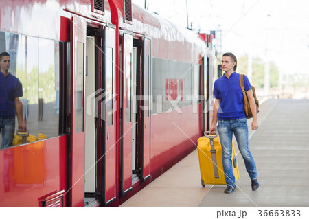 Young caucasian man with luggage at station 36663833