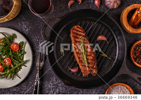 Beef steak on a dark background. 36669346