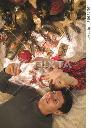 Father and son laying under christmas tree. Father and son laying under christmas tree. 36671564