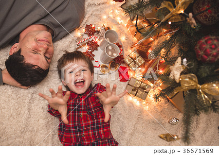 Father and son laying under christmas tree. Father and son laying under christmas tree. 36671569