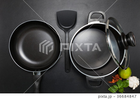 Top view frying pan and pot on black table. Top view frying pan and pot on black table. 36684847