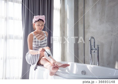 Beautiful girl shaving leg hair by razor 36693148