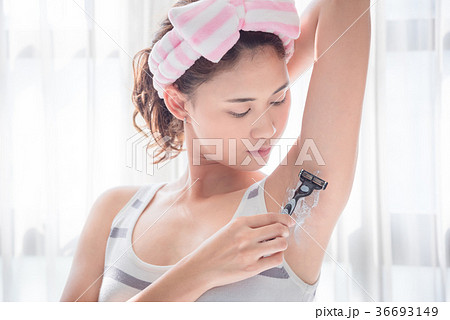 Beautiful girl shaving armpit hair by razor 36693149