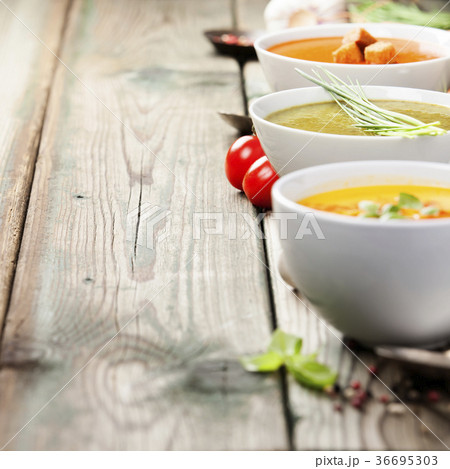 Variety of cream soups over old wood background Variety of cream soups over old wood background 36695303