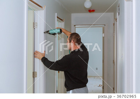 Carpenter brad using nail gun to moldings  36702965