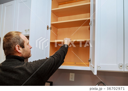Closeup of a cabinet installer installing hardware 36702971