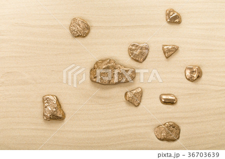 Golden stones on waved sand. 36703639