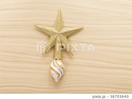 Glitter christmas star topper on sand. 36703640