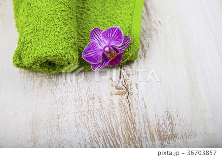 Green towel and orchid close-up. 36703857