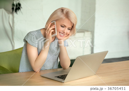Girl working on computer and talking phone 36705451