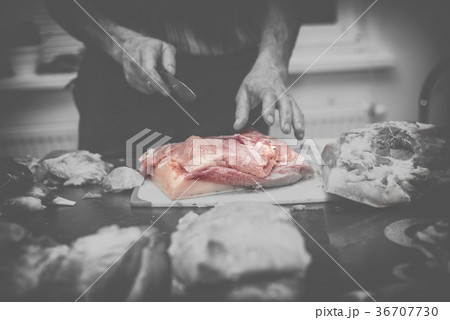 Man slicing pork meat on a table, conceptual idea Man slicing pork meat on a table, conceptual idea 36707730