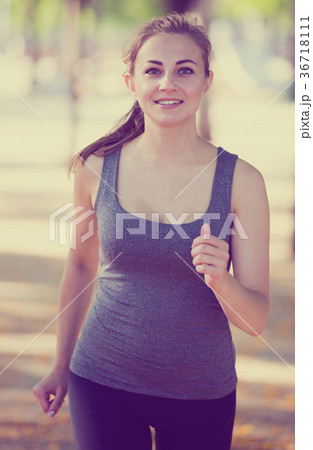 happy female in sportwear running in the sunny park happy female in sportwear running in the sunny park 36718111