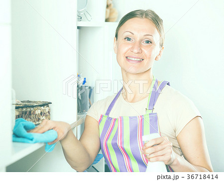 Positive woman wiping shelves 36718414