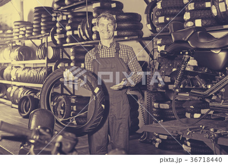 Man standing with new tires for motorbike 36718440