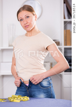 Woman trying to zip up jeans Woman trying to zip up jeans 36718514
