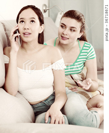Girl eavesdropping phone conversation of friend 36718671