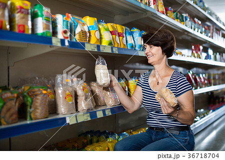 Pensioner selecting a groats at the store 36718704