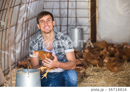 Happy countryman holding brown chicken Happy countryman holding brown chicken 36718816