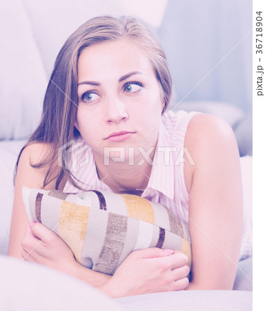 Sad woman on sofa with pillow Sad woman on sofa with pillow 36718904